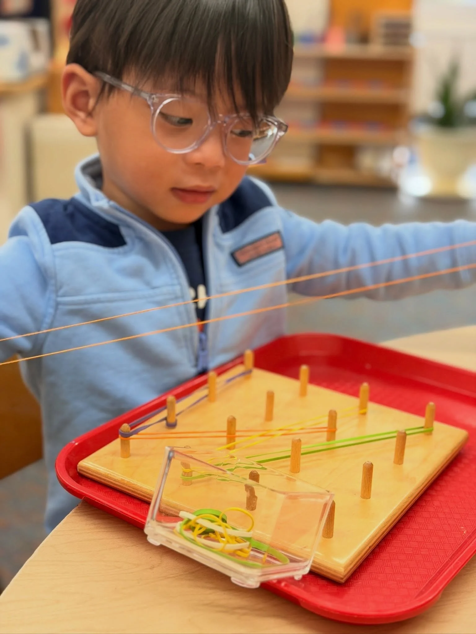 Stretching rubber bands across a peg board is a wonderful exercise in concentration, coordination, and creativity! As children carefully manipulate the bands around the pegs, they strengthen fine motor skills, develop hand-eye coordination, and explo