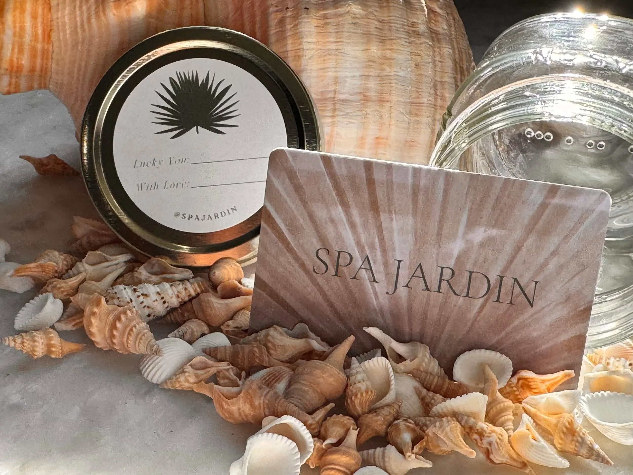 A Spa Jardin gift card with sea shells and glass jars