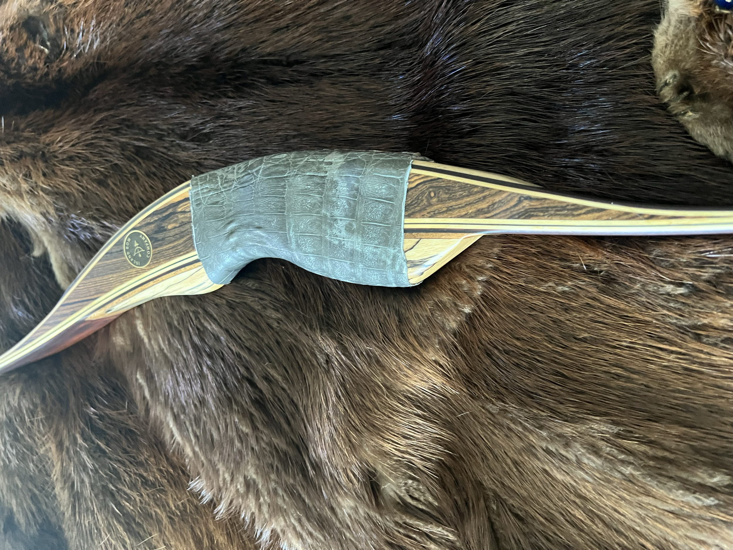 Close-up of a phonograph stylus resting on a brown furry animal, possibly a bear, with a decorative gold and wood grain design on the phonograph arm.