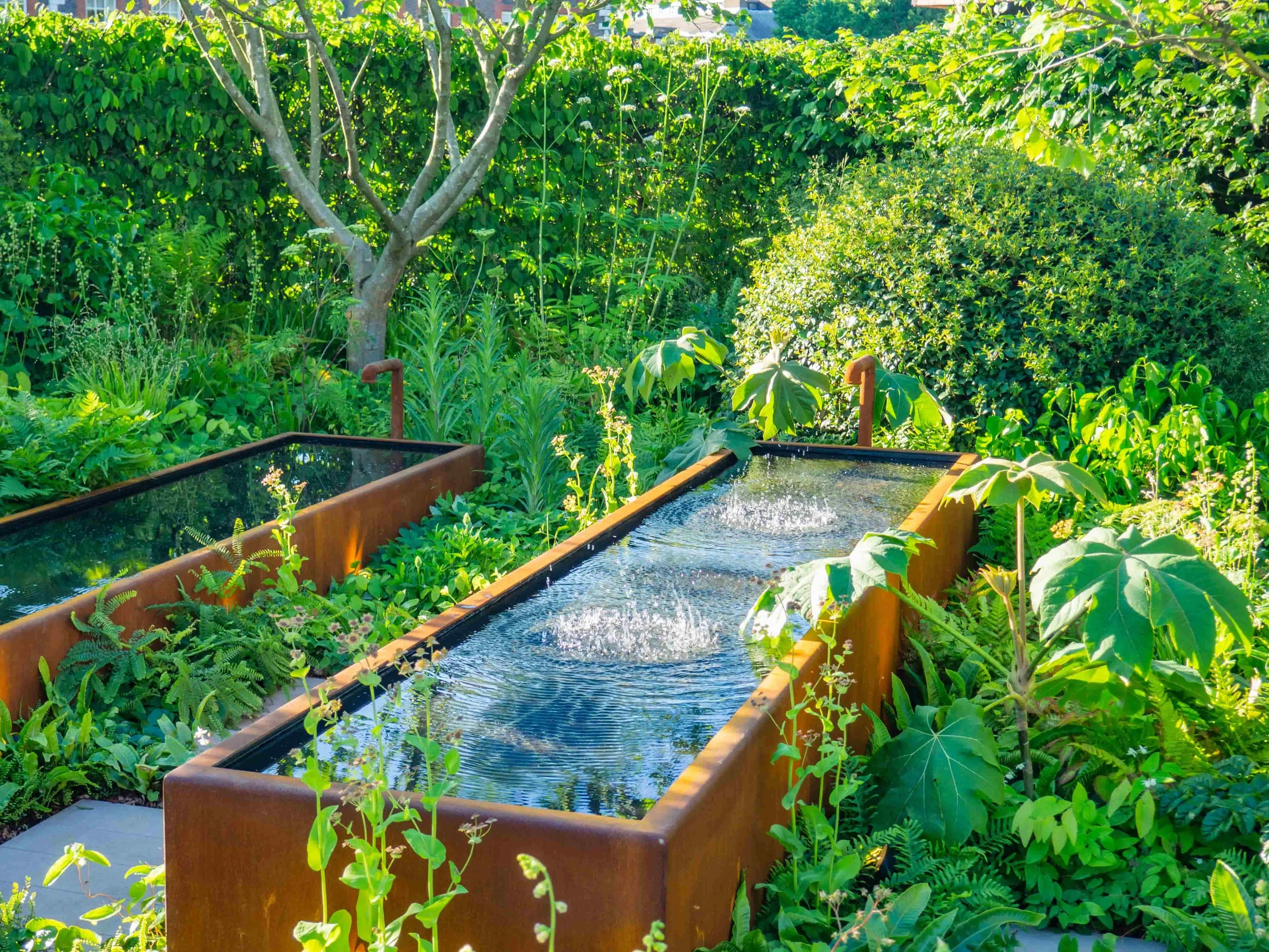Corten water feature troughs in a lush garden