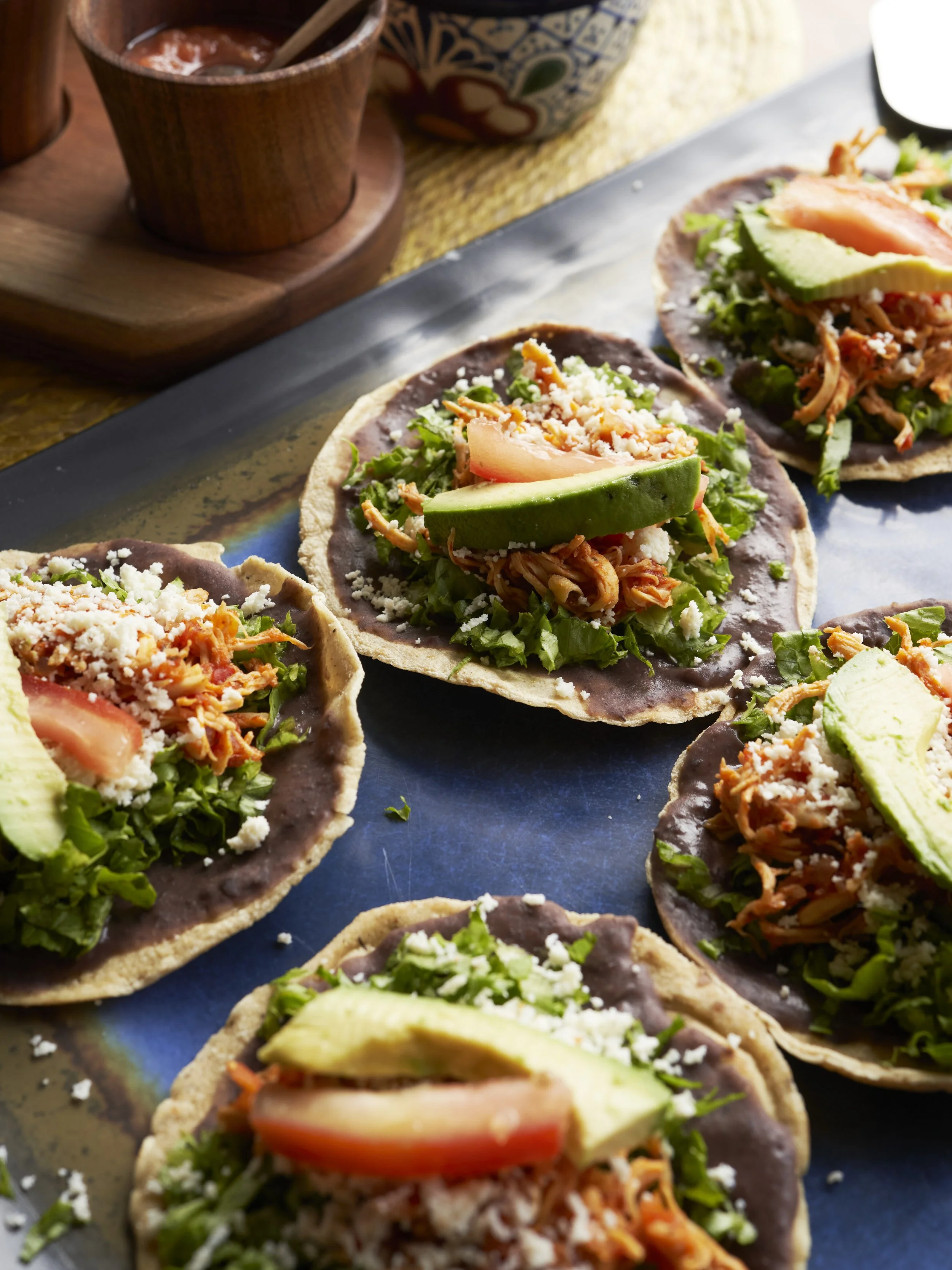 Tacos de maíz con frijoles, pollo, lechuga, tomate, aguacate y queso