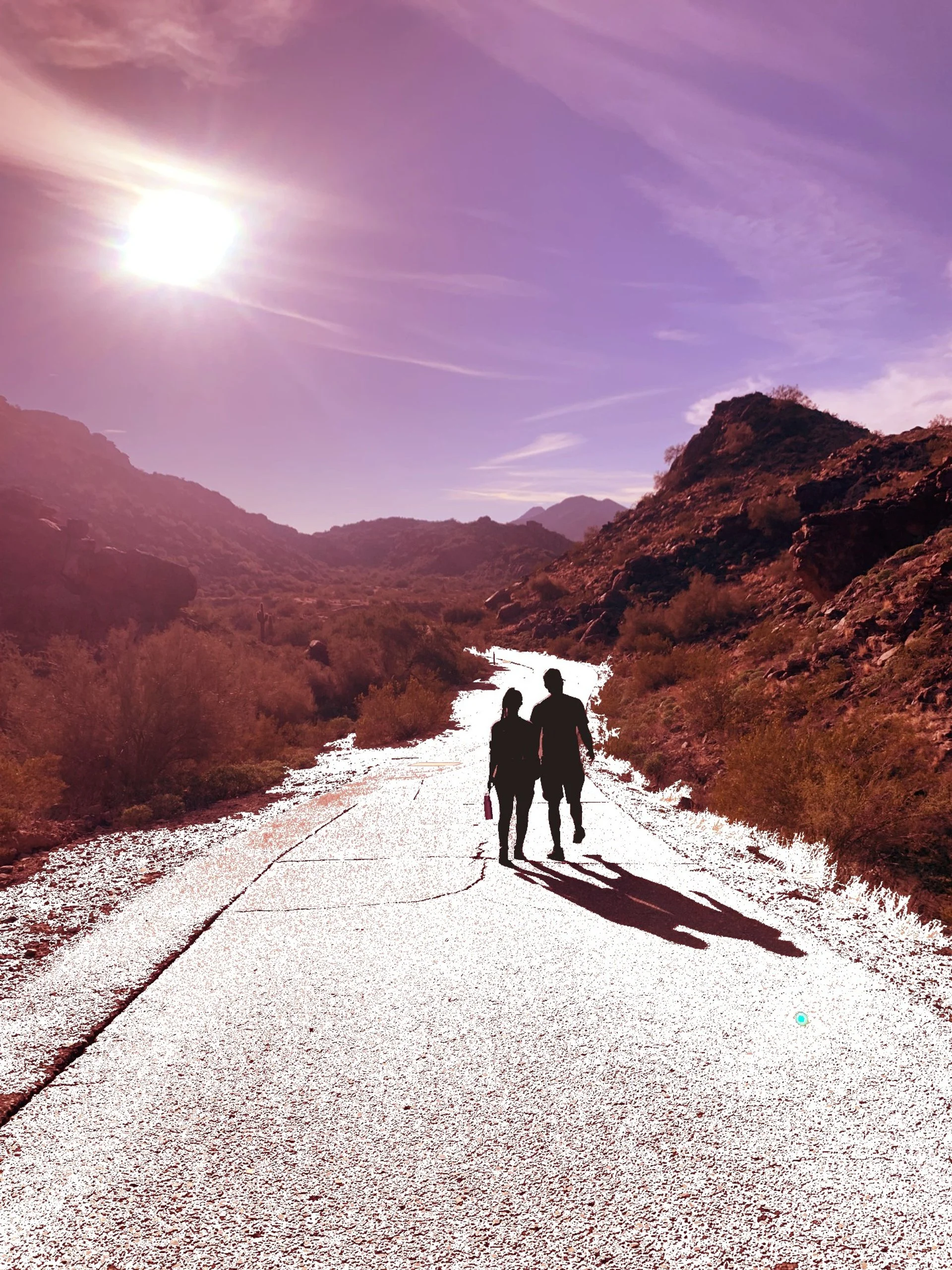 Silhouettes of a man and woman walking on a paved road through desert terrain with mountains nearby, under a bright sun in a purple-hued sky.
