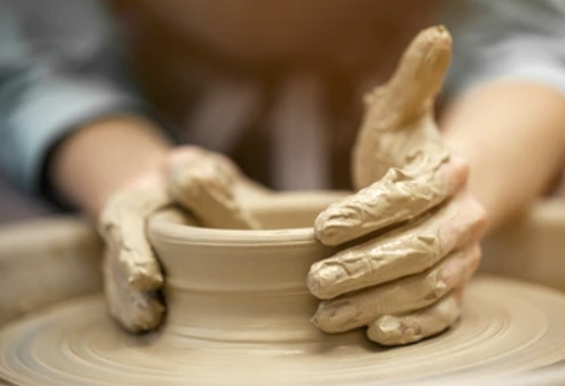 Creating handmade pottery on a pottery wheel with their hands.