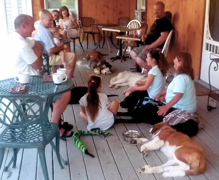 Human and canine guests enjoying breakfast on the porch of a Vermont inn