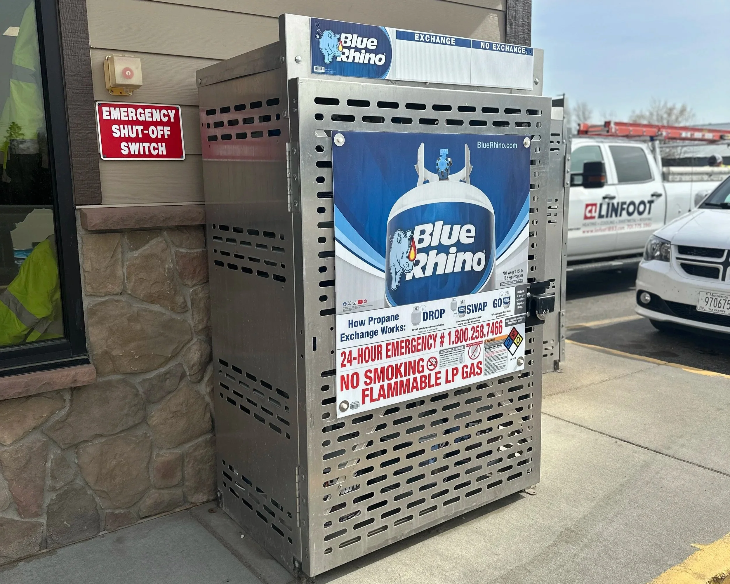 Propane tank exchange machine with Blue Rhino branding and warning signs, located at an outdoor retail or service station.