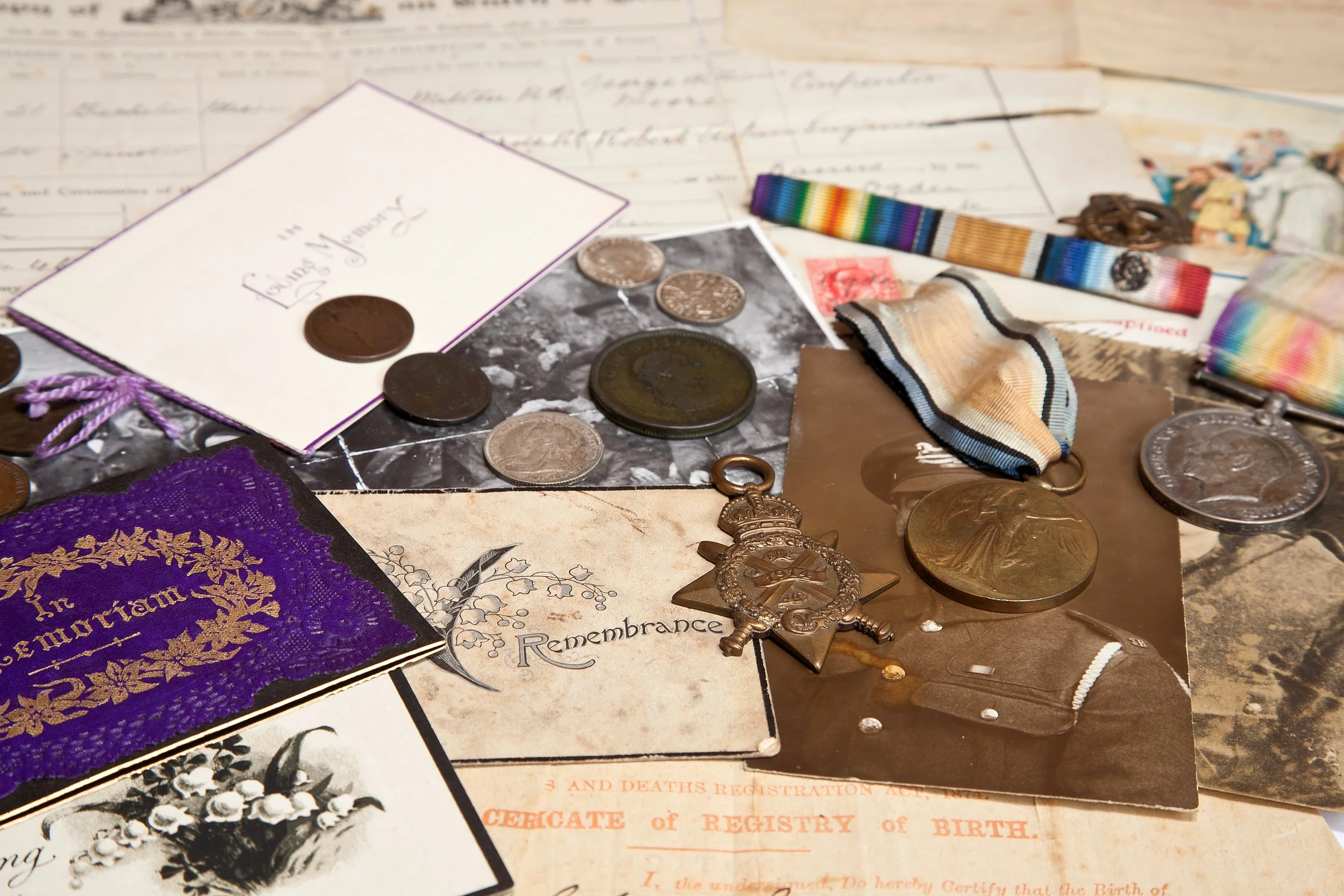 A collection of vintage military memorabilia and collectibles, including medals, coins, and old documents.