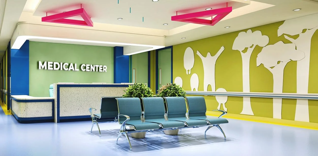 Interior of a medical center with a reception desk, a row of blue waiting chairs, potted plants, and a wall with a tree mural.