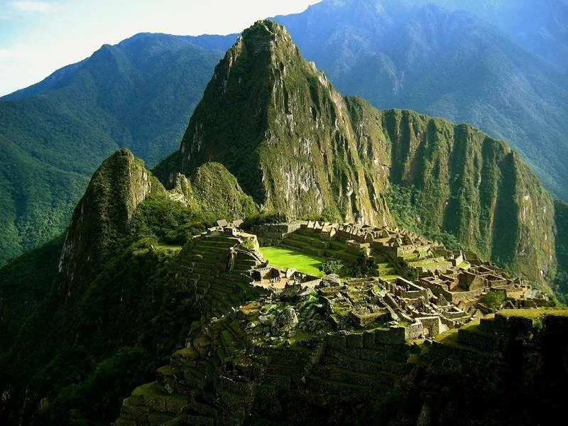 Ancient Incan ruins of Machu Picchu with mountainous landscape and greenery in Peru.