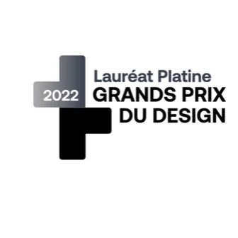 Logo avec texte "Lauréat Platine 2022 Grands Prix du Design" et des formes contrastées en gris, noir et blanc.