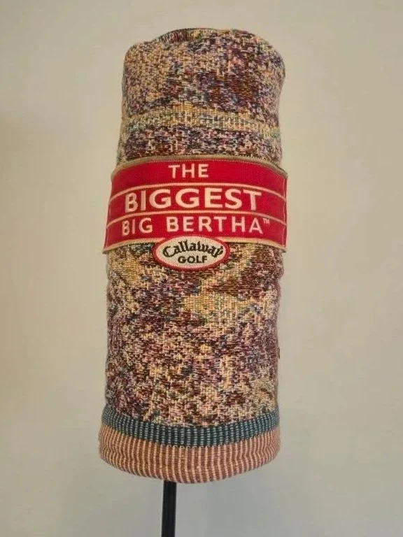 A rolled-up golf towel with a red band reading "The Biggest Big Bertha" on a plain background.