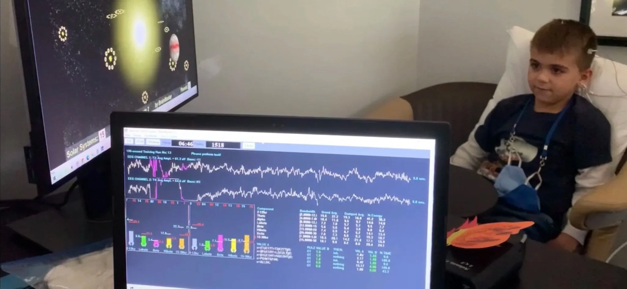 Child watching brainwave data on monitors during a neurofeedback session at Kerov Health