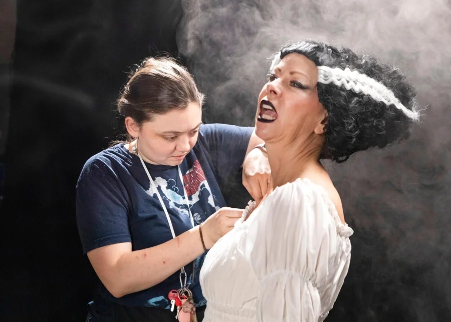 Emily Bird-Hounihan adjusts the bride of Frankenstein dress as Julie maintains character.