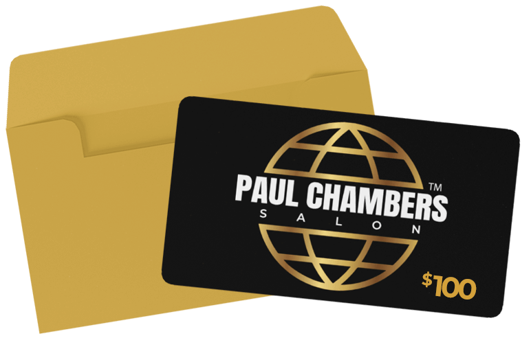A black gift card with a gold globe logo, the text 'Paul Chambers Salon,' and a value of $100, placed in front of a gold envelope.