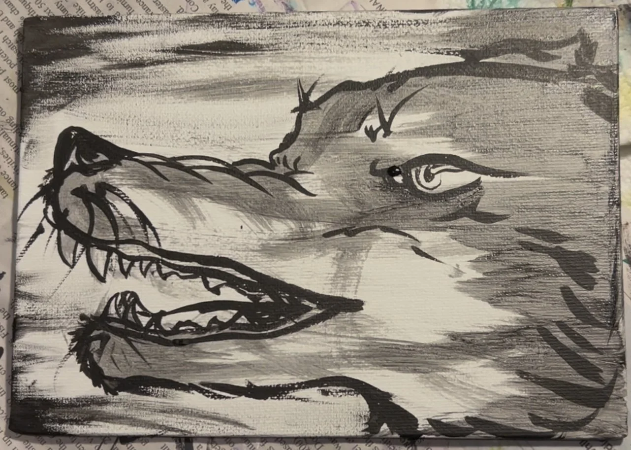 A black and white ink drawing of a wolf's head with its mouth open, showing sharp teeth, and an eye looking to the side.