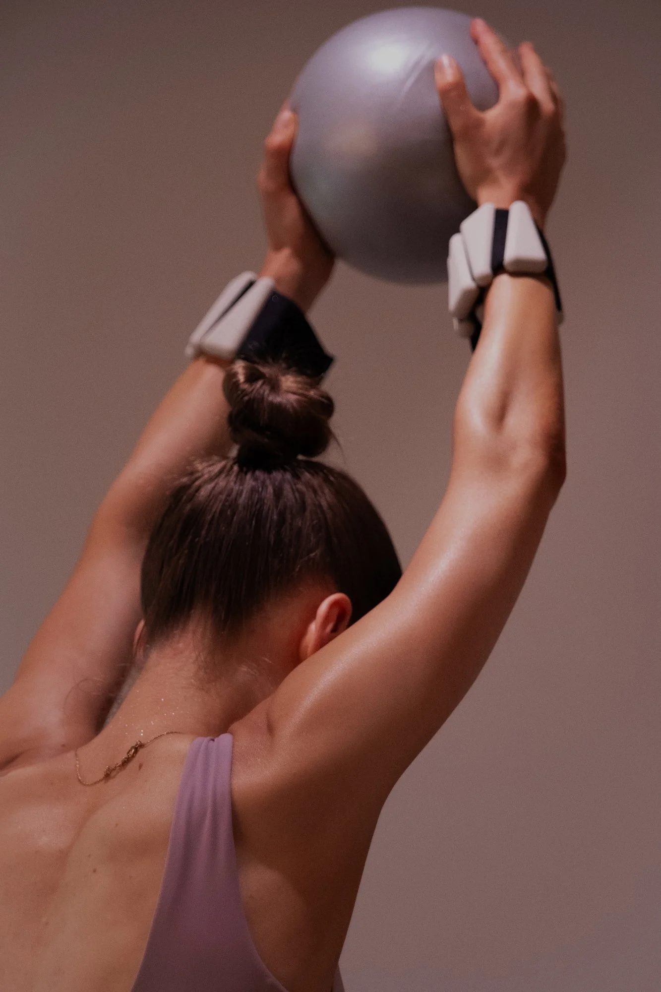 A woman practicing yoga balancing on a stability ball in a minimalistic room.