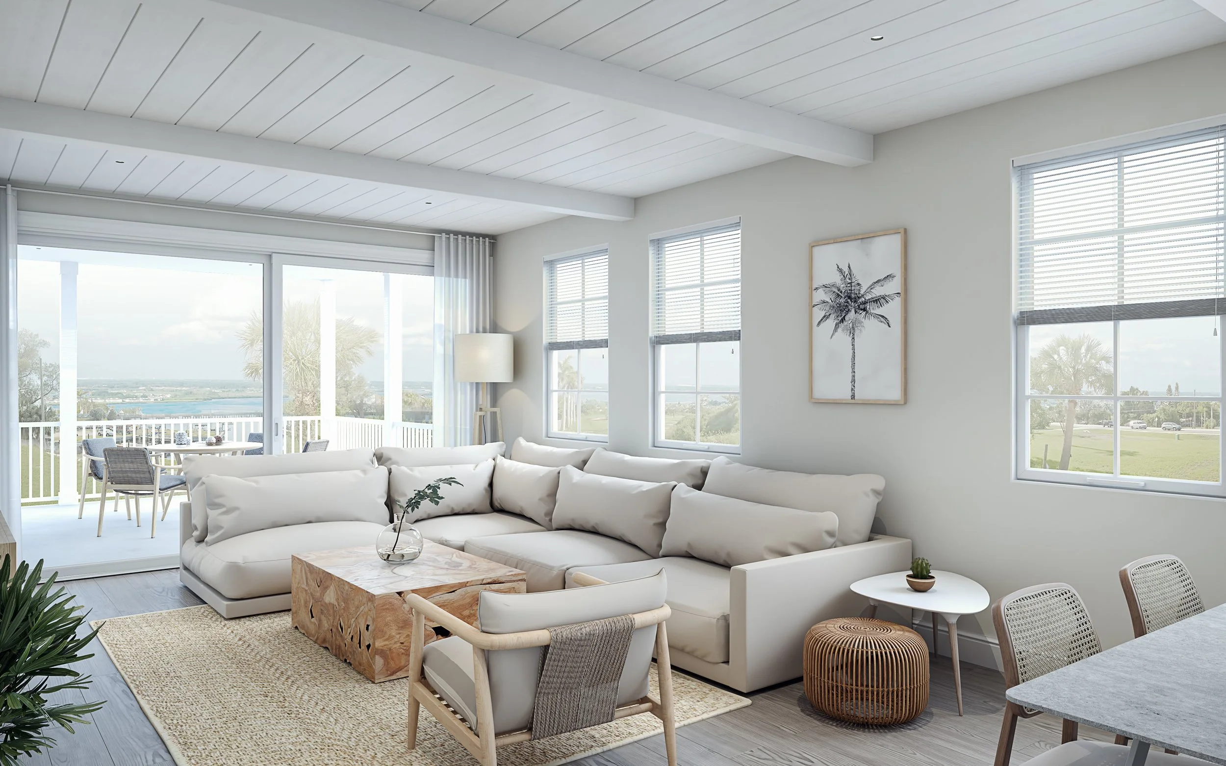 Bright living room featuring a white sectional sofa, beige armchair, glass coffee table, and a textured ottoman. Large windows and sliding glass door lead to a balcony with outdoor dining, overlooking a landscape with water and palm trees.