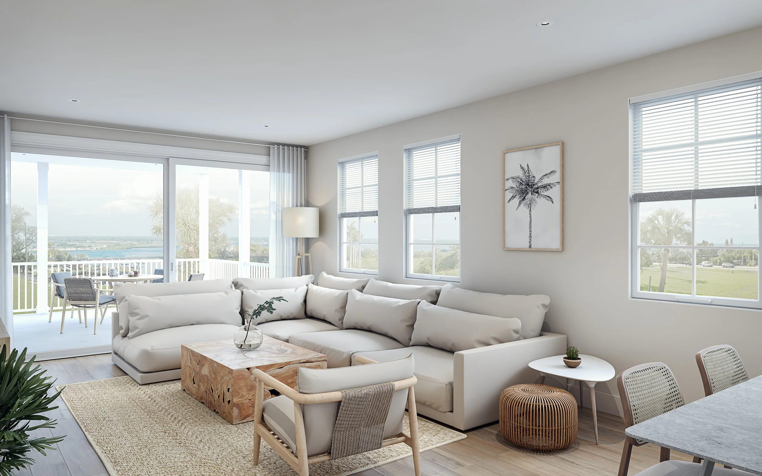 Bright living room with white sectional sofa, armchair, coffee table, and large windows with blinds, overlooking a balcony with outdoor dining area and a scenic view.