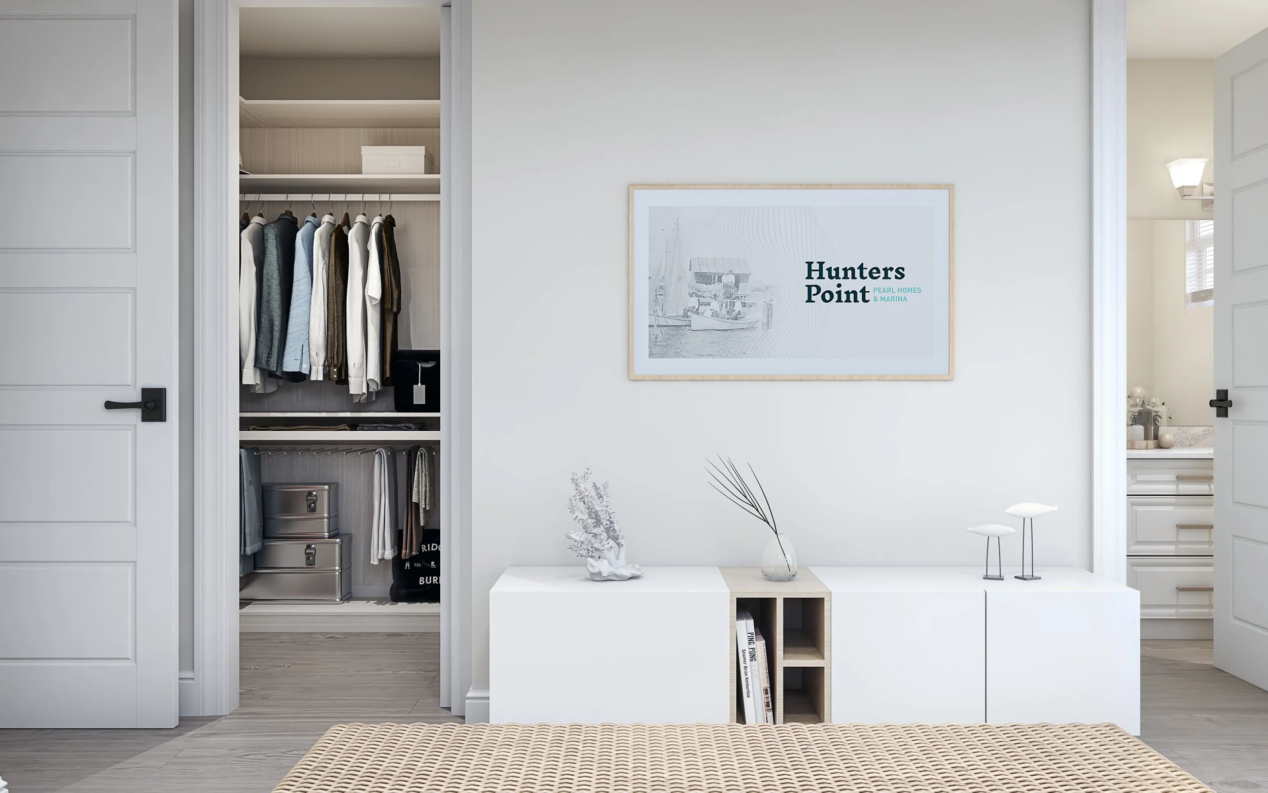 Interior of a bedroom showing open closet with hanging clothes, storage boxes, and a partially visible bathroom. White walls and modern decor with minimalist furniture.