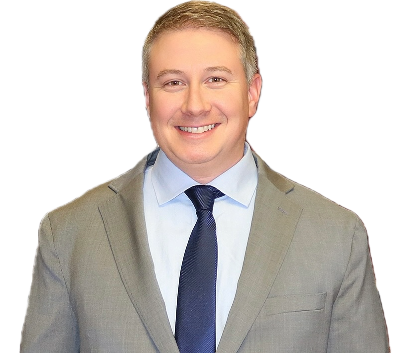 A smiling young man in a gray suit, white shirt, and dark tie, standing against a plain background.