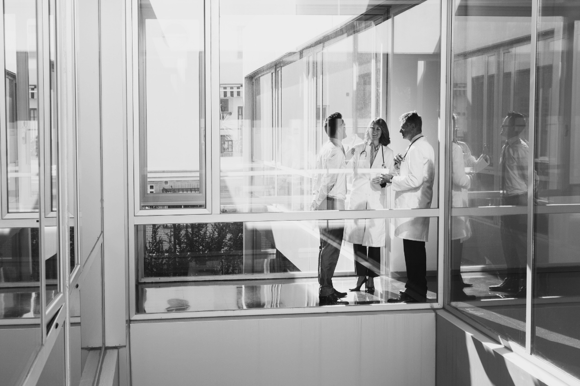 Healthcare professionals in discussion inside a modern hospital building.