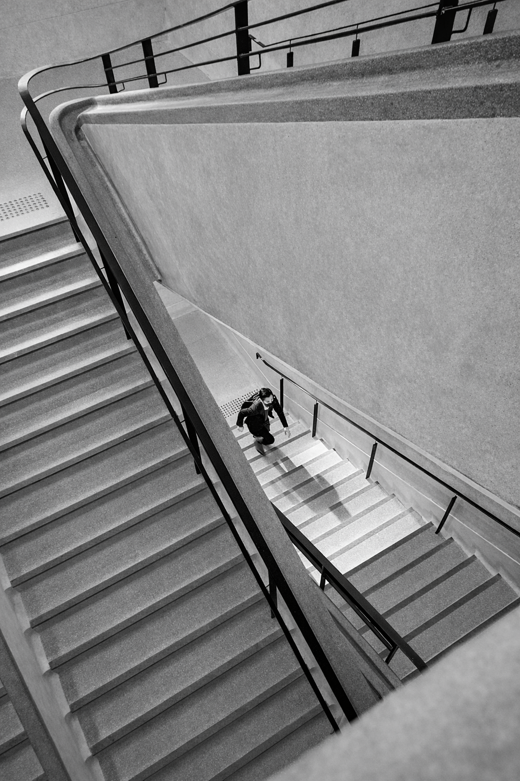 Person walking up a modern staircase, symbolizing progress and long-term direction.