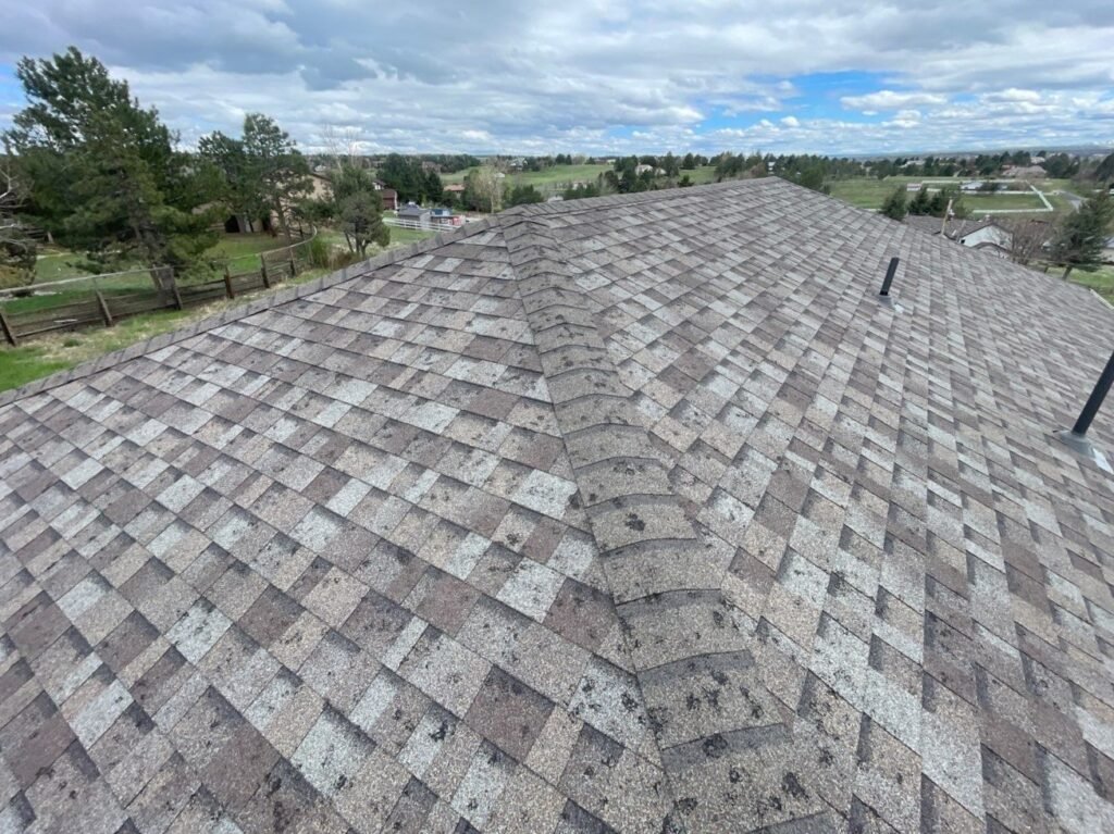 Detailed drone roof inspection image showing shingle surface, ridge lines, and visible hail impact marks. Roofing inspection photography for insurance claims and repair estimates.