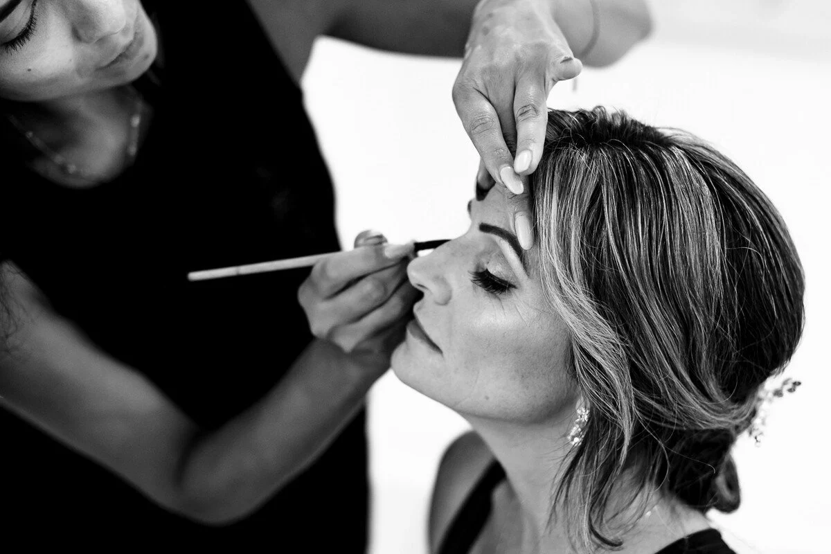Woman getting makeup applied by a makeup artist.