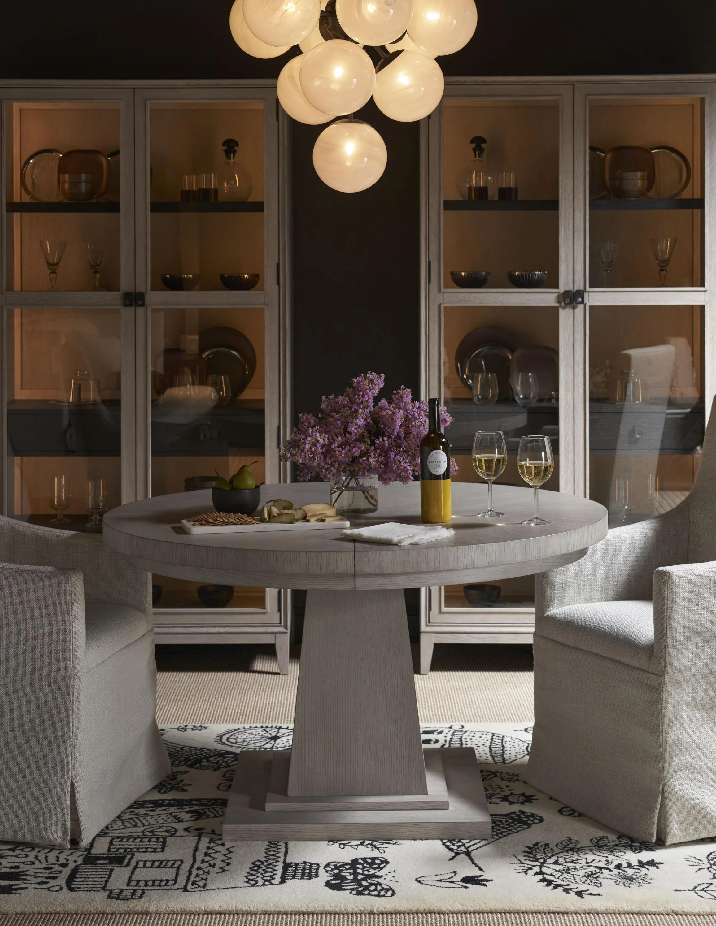 The Rasmus Round Dining Table, robust in form and finished in the tranquil Rolling Fog, is accentuated with a unique square detail on the tabletop, adding an understated geometric touch to this sturdy and elegant dining essential.