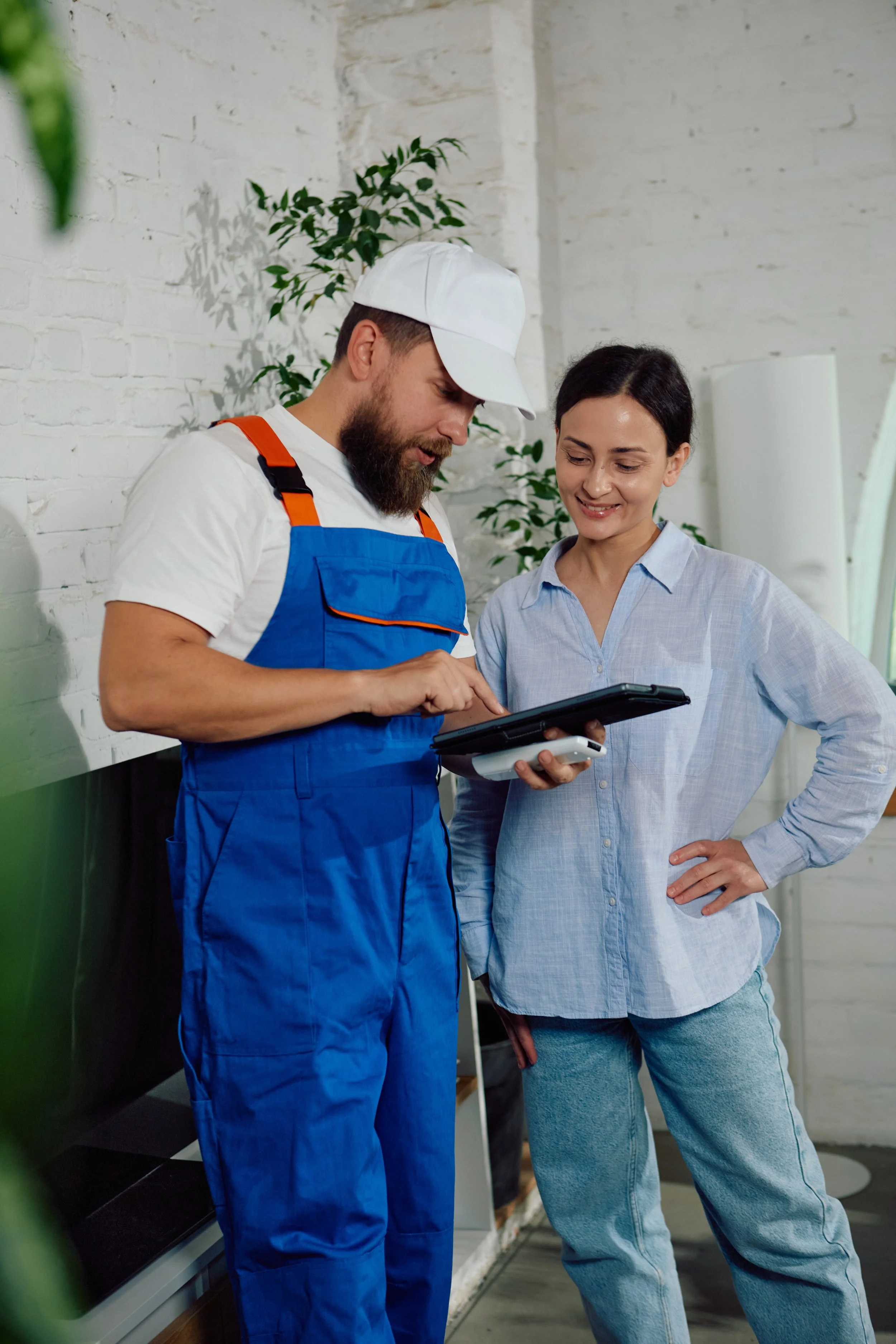 HVAC technician taking notes while discussing air conditioning repair with a homeowner