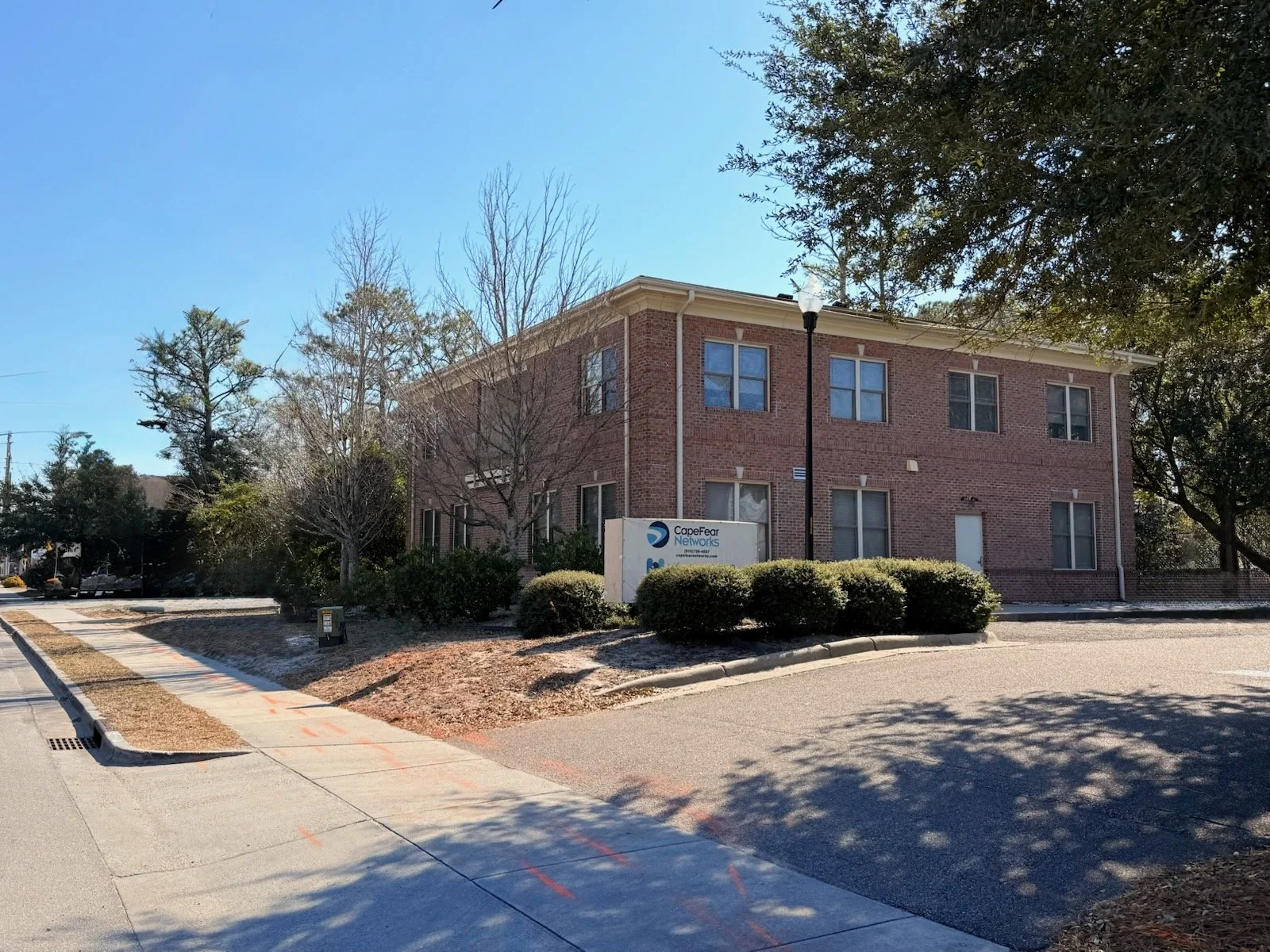 The brick office building, surrounded by trees and bushes, located on Racine Drive where Wilmington Couples Counseling offers in-person sessions.
