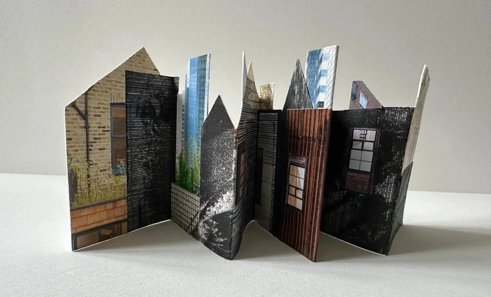Untitled:
Mixed media concertina cityscape on paper. 
1/1
Concertina dimensions: 10cm x 49cm.
Tin dimensions: 8cm x 11cm x 3cm.