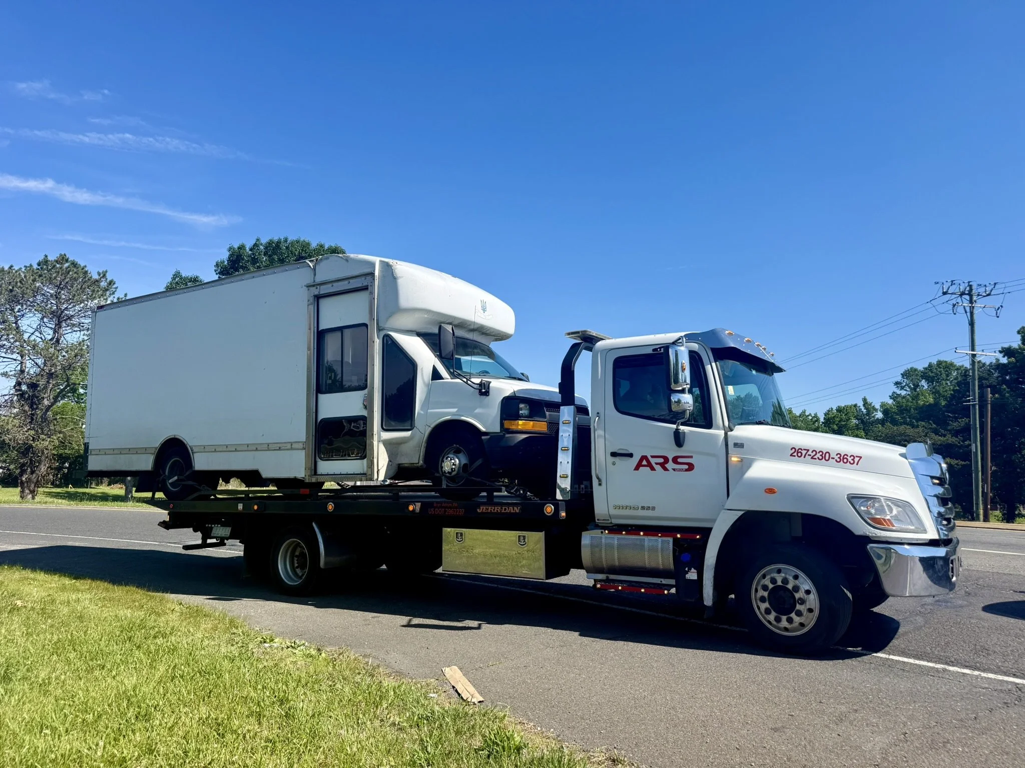 ARS Towing flatbed tow truck parked near the Huntingdon Valley community sign in Huntingdon Valley, PA
