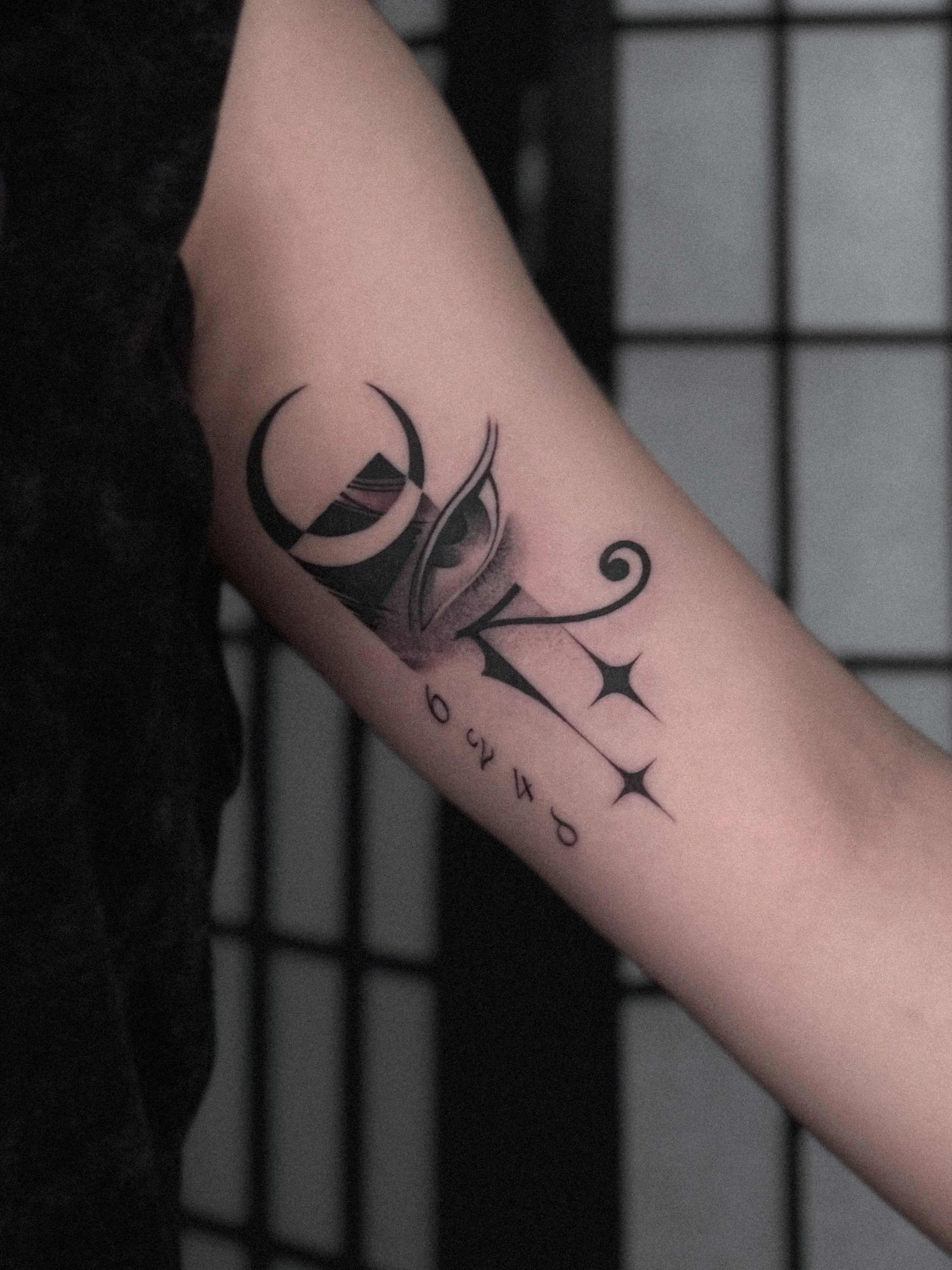 Tattoo on person's inner forearm featuring abstract black lines, stars, a crescent moon by Dmytro Shcherbakov