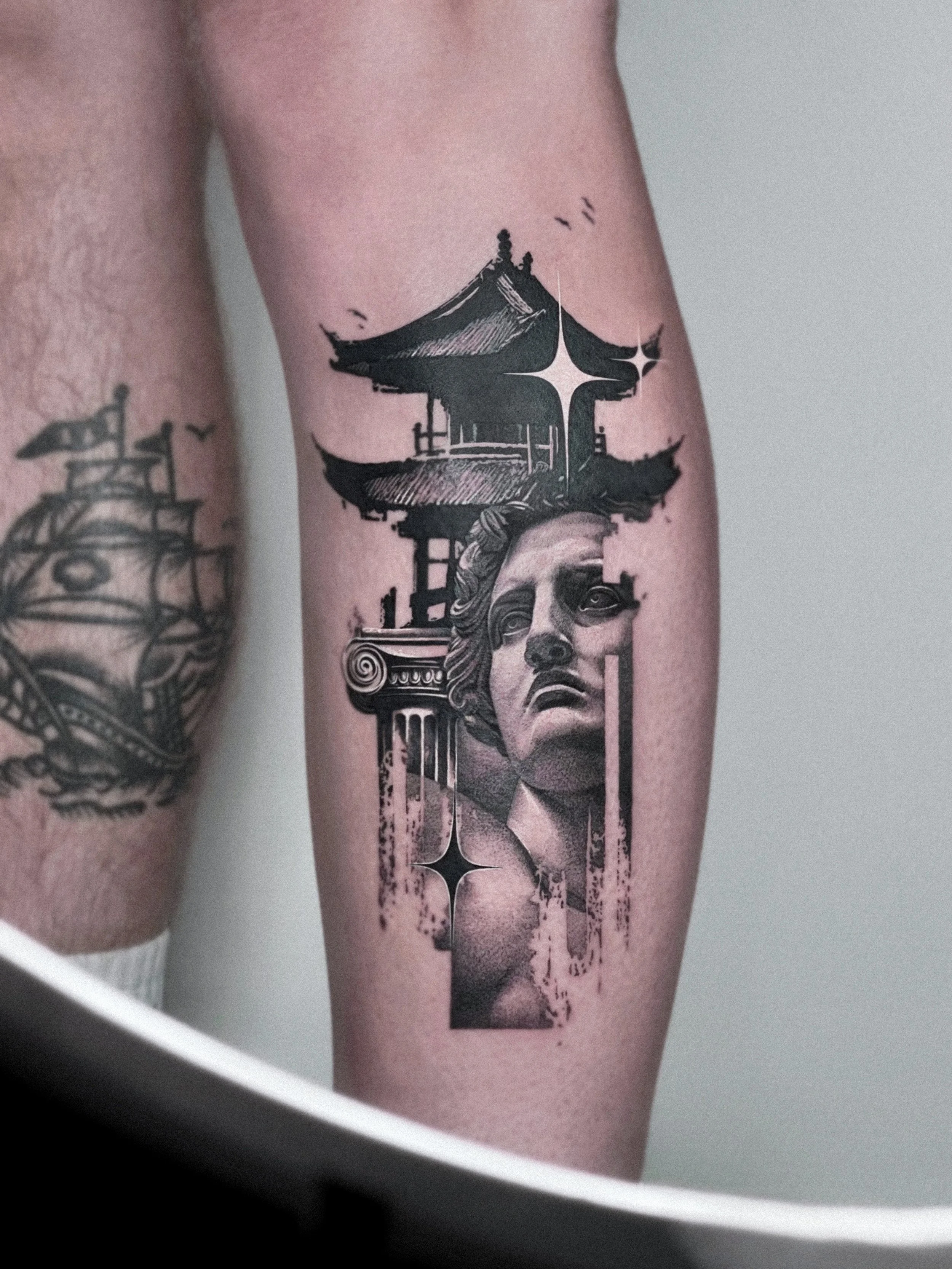 Tattoo of a classical sculpture of a woman’s face with traditional Asian temple structures above, by Dmytro Shcherbakov