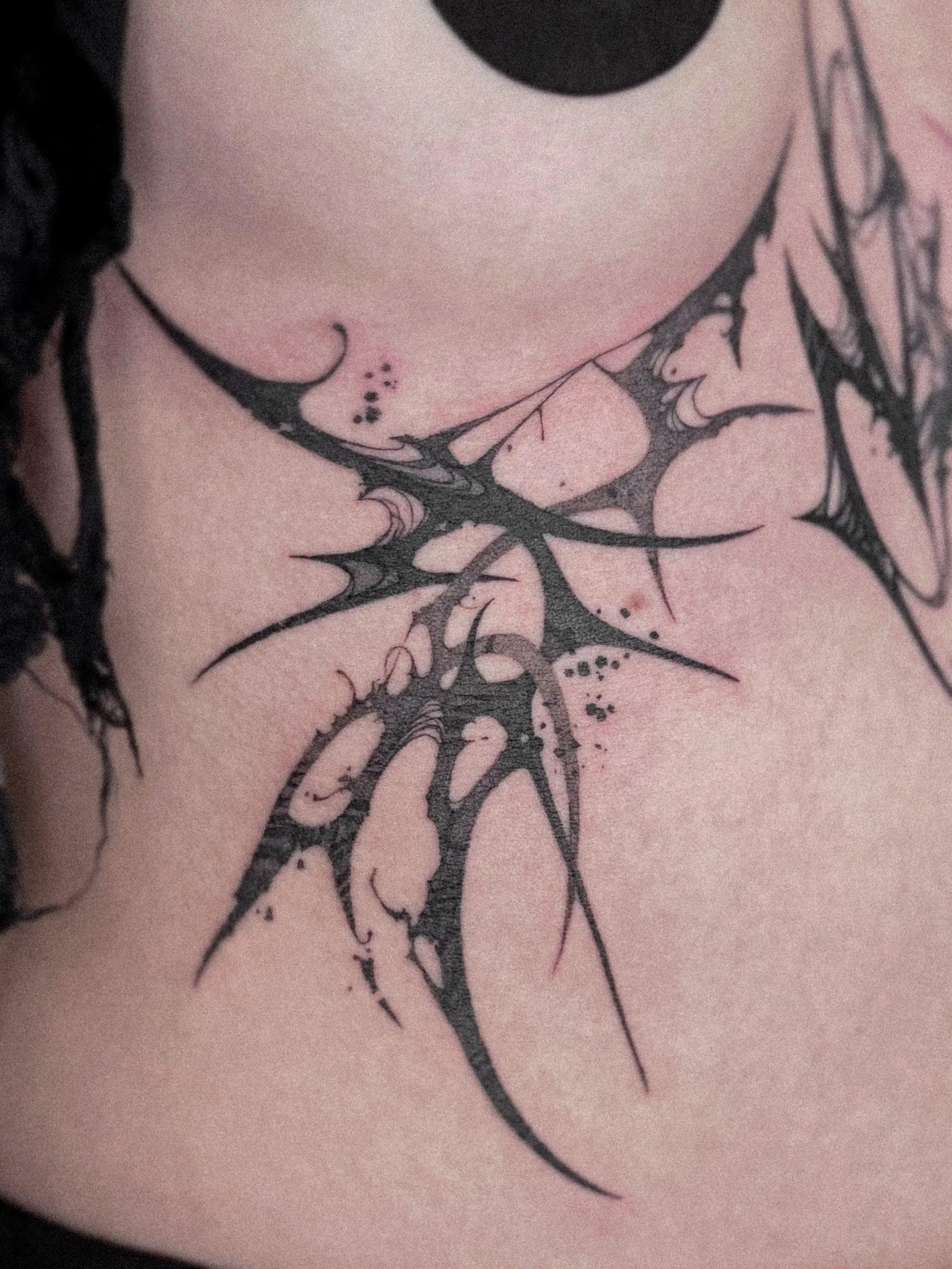 Close-up of a black tribal-style tattoo by Dmytro Shcherbakov