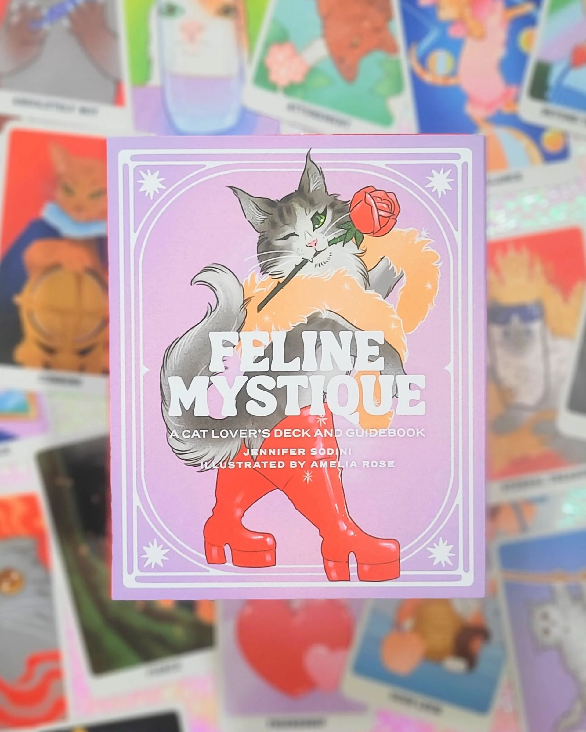 Book cover titled 'Feline Mystique' featuring a gray and white cat holding a red rose with its mouth, wearing red platform boots, set against a purple background with decorative borders.