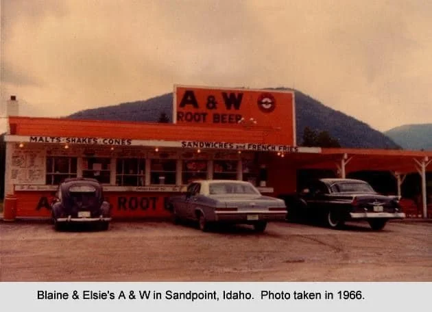 A&W Root Beer stand in Sandpoint, Idaho, with three vintage cars parked in front, and a mountain in the background, taken in 1966.