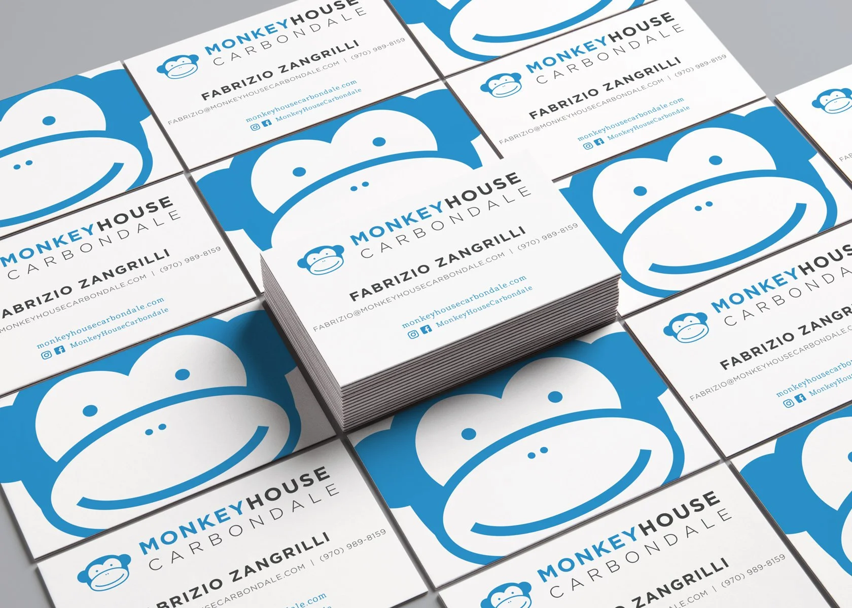 Stack of business cards for Monkey House Carbondale featuring a blue and white logo of a monkey's face, with contact information for Fabrizio Zangrilli.