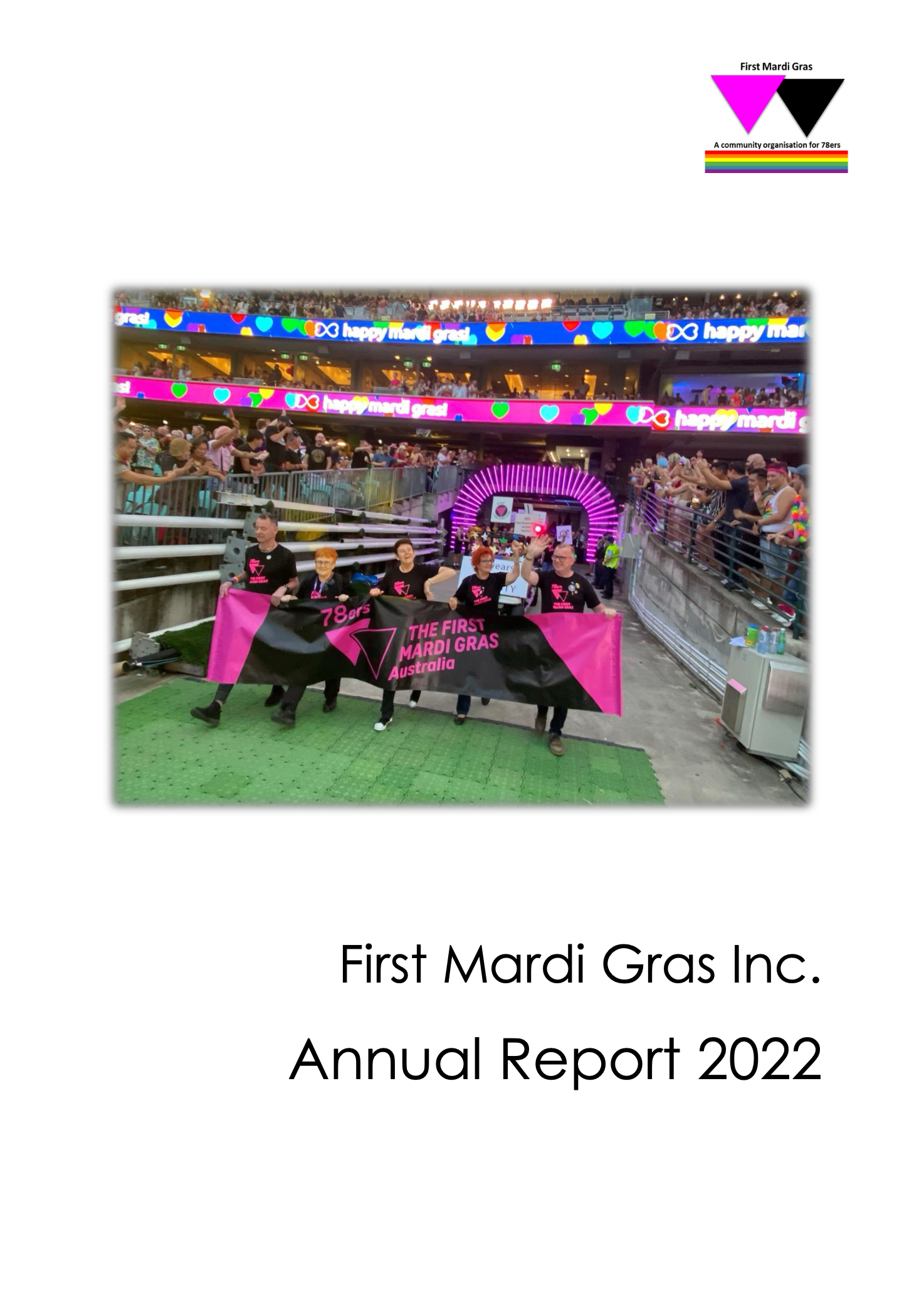 A group of people holding a pink and black banner that reads '78ers THE FIRST Mardi Gras Australia' in front of a crowd at a Mardi Gras parade with colorful digital signs and lights.