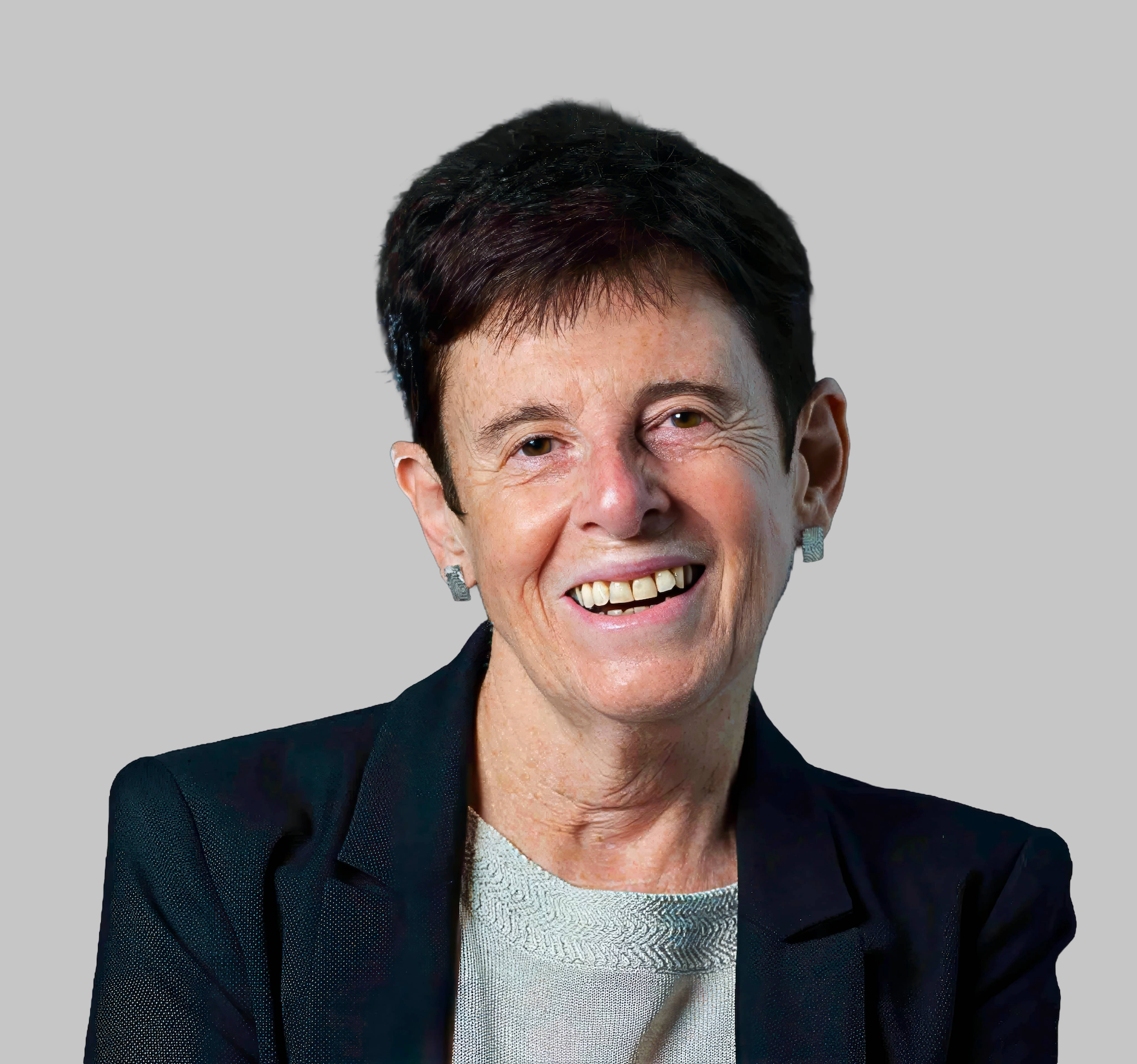 Portrait of a smiling woman with short dark hair, wearing a black blazer and earrings, against a plain background.