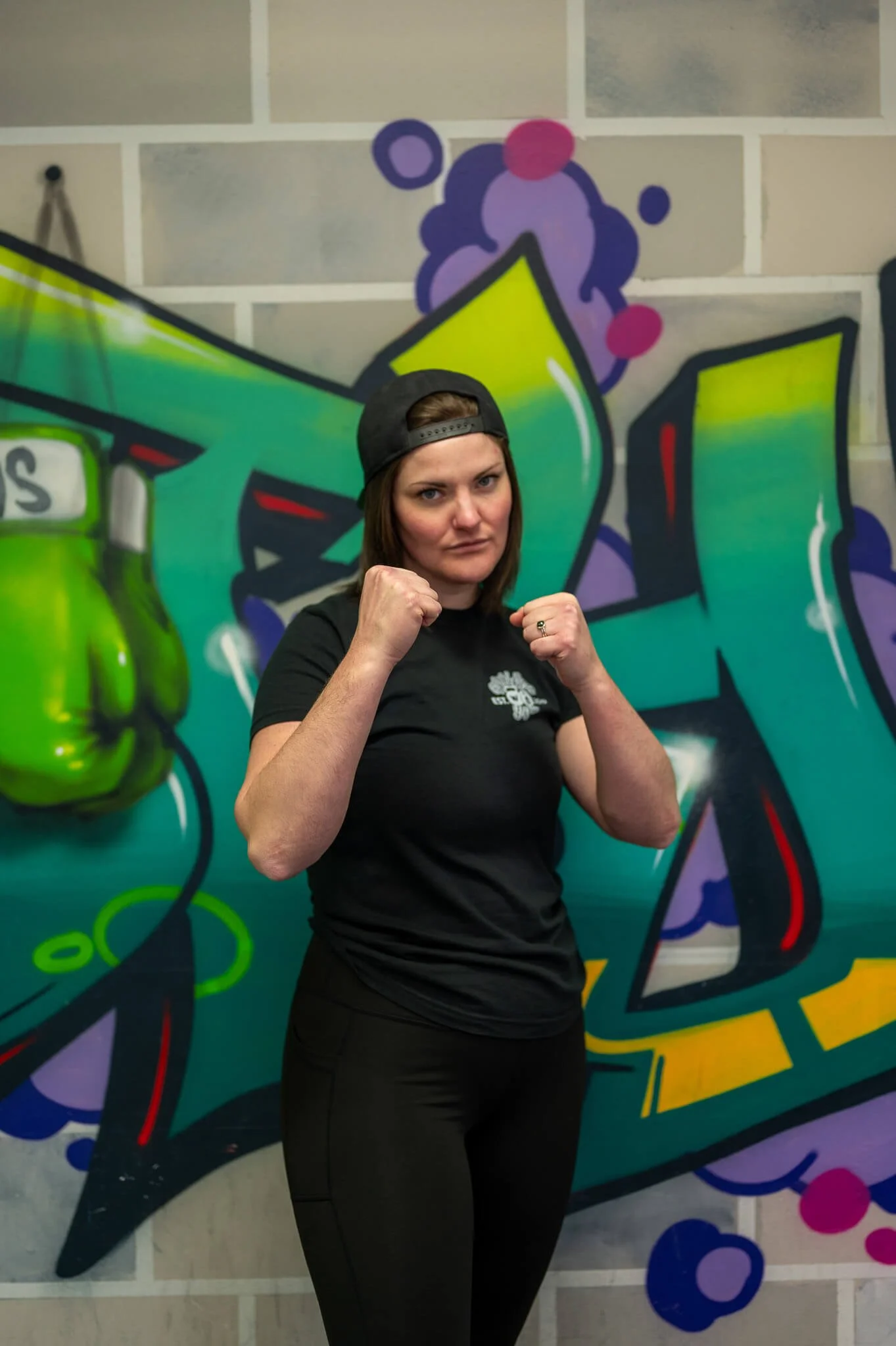 Coach Maggie demonstrating a boxing stance at WildStyle Gym in Snohomish, WA, highlighting athleticism and striking fundamentals.