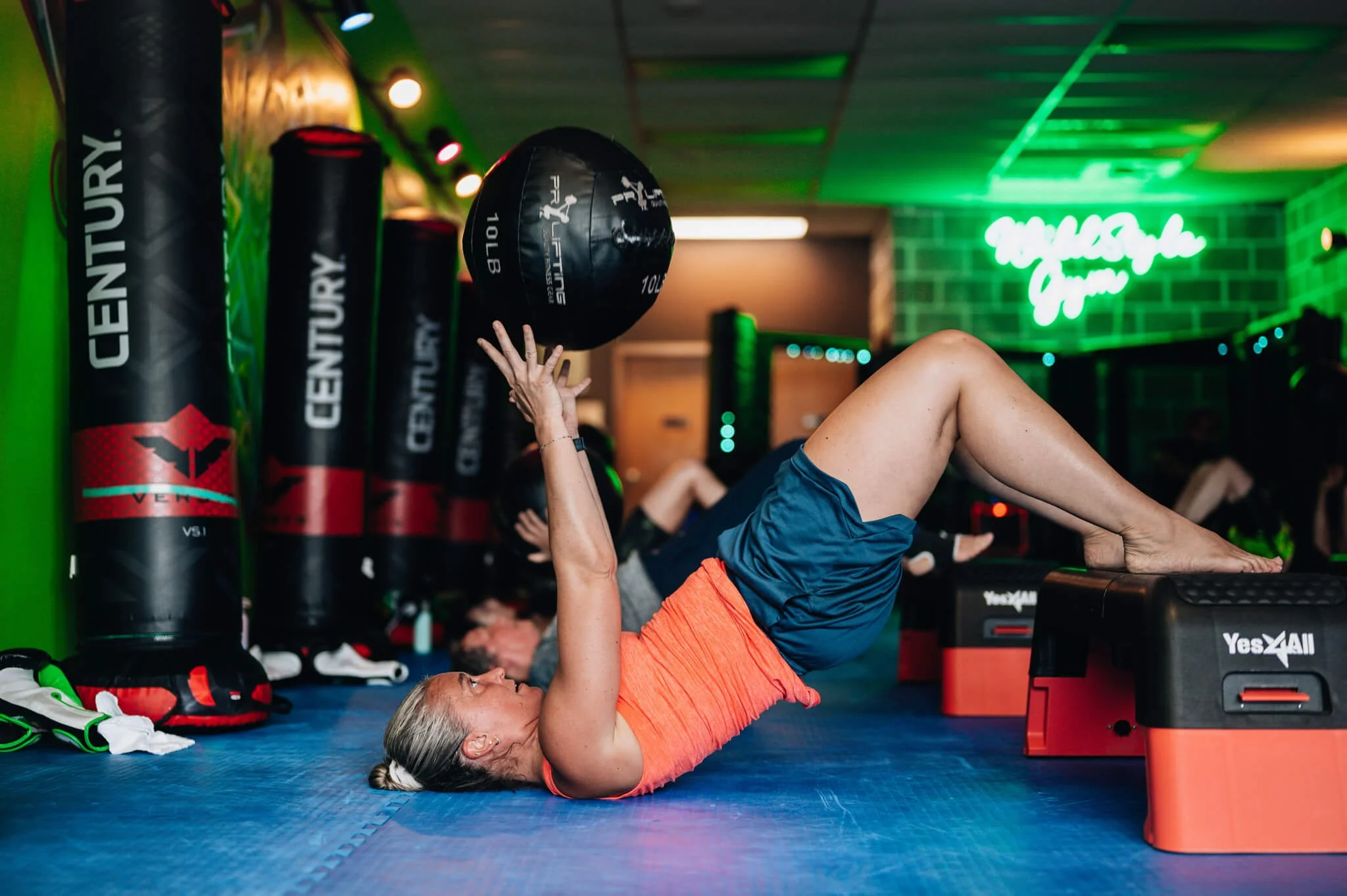 Member performing a glute bridge with a medicine ball during Champ Camp HIIT training at WildStyle Gym in Snohomish, WA.