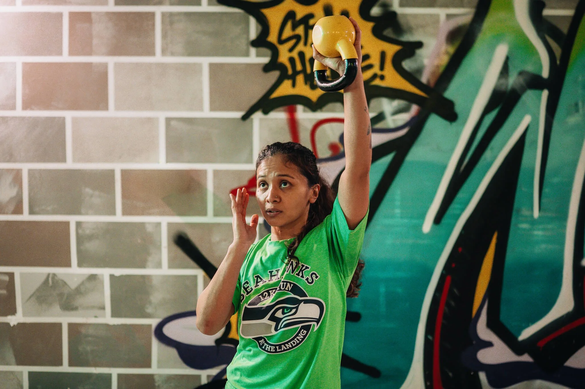 Woman performing an overhead kettlebell lift during Champion Strength small group training at WildStyle Gym in Snohomish, WA.