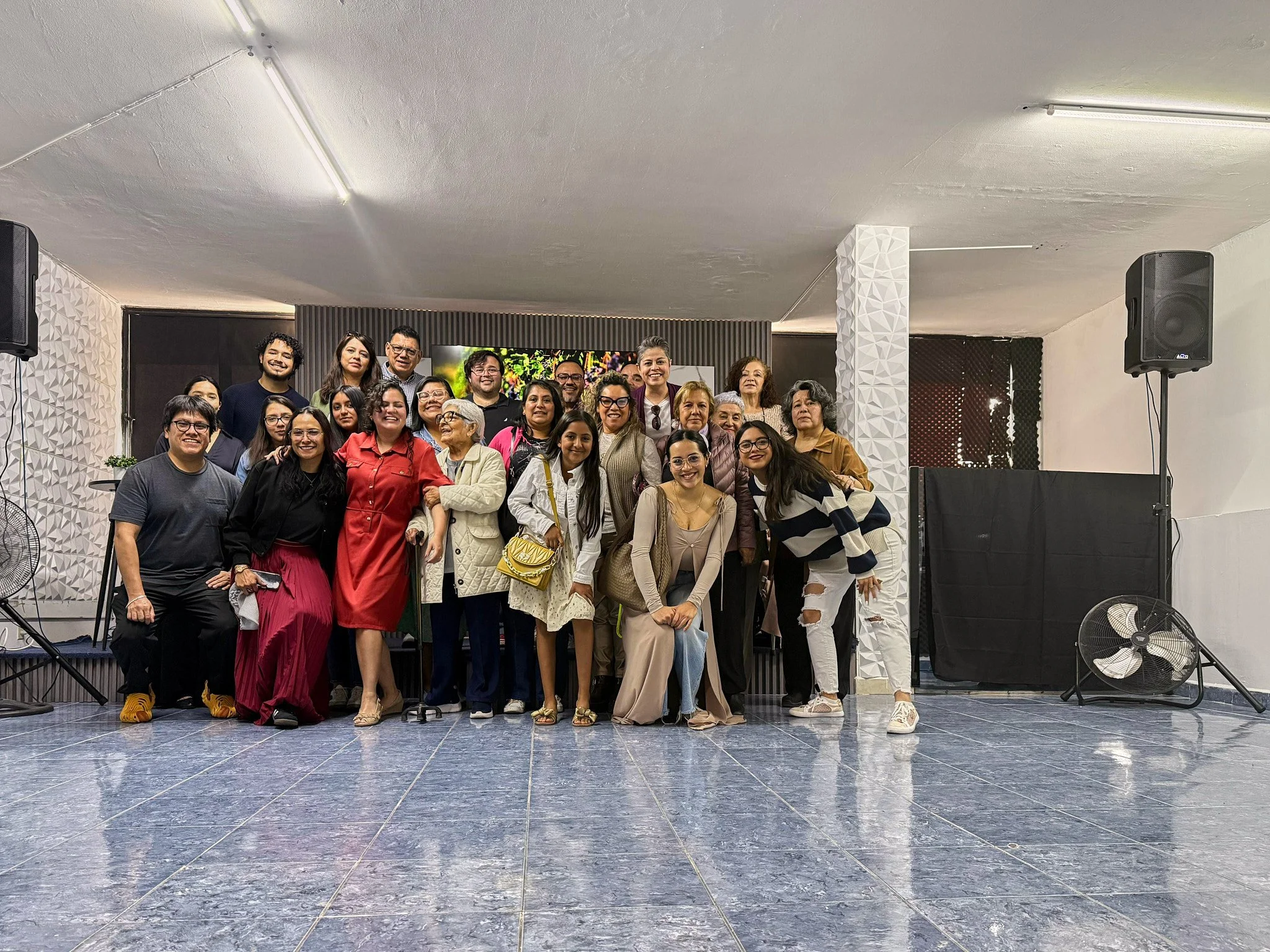 Grupo de personas posando para una foto en un espacio interior.