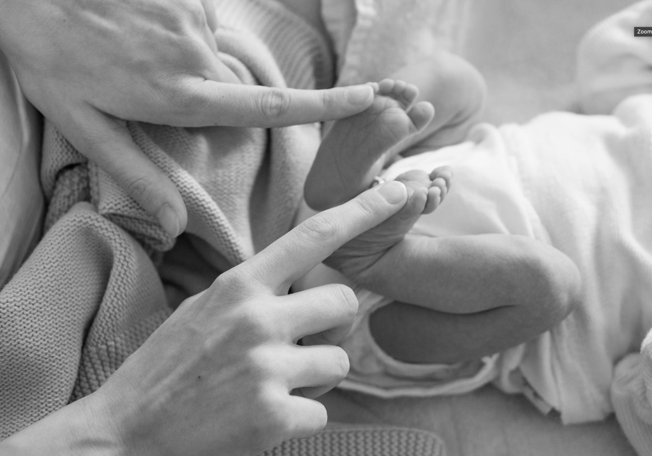 Une main adulte tenant délicatement la main d'un bébé, symbolisant le lien entre un adulte et un enfant en bas âge.