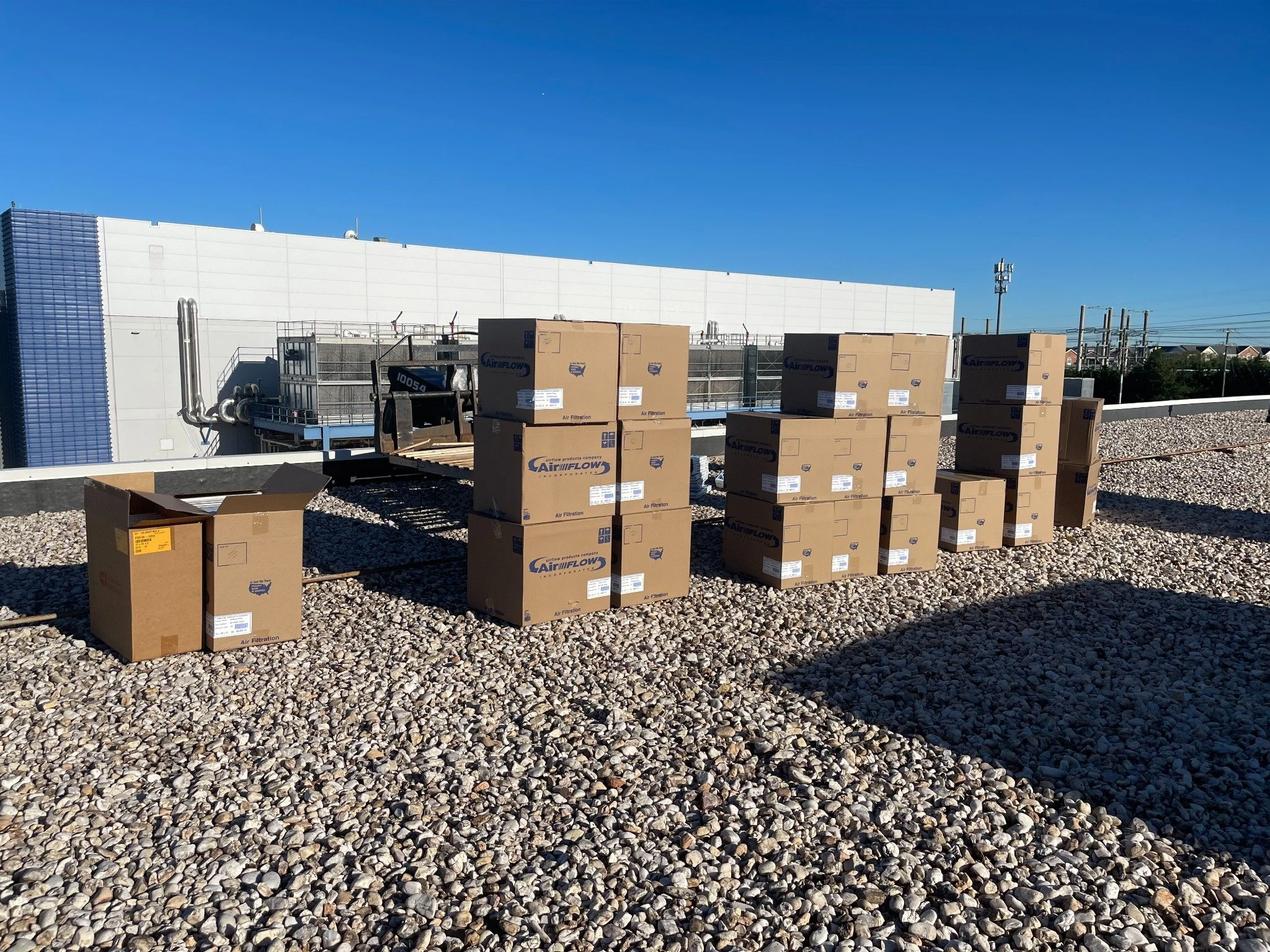 Commercial HVAC filter replacement — replacement filters staged on the roof.