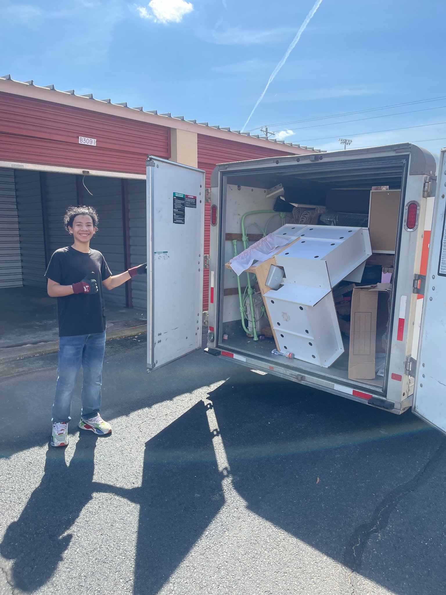 Woodbridge storage unit cleanout — loaded trailer beside the cleared unit.