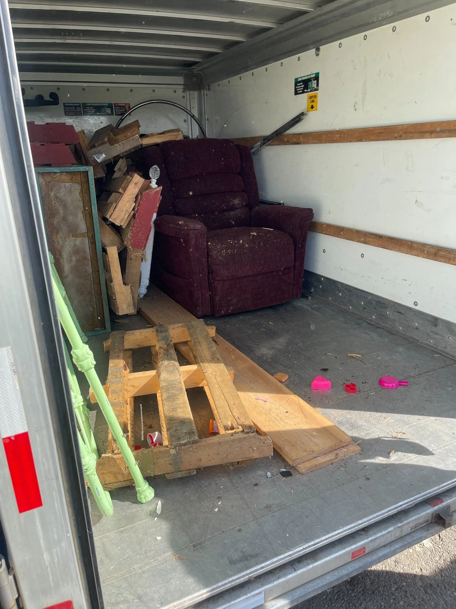Woodbridge storage unit cleanout — furniture and wood loaded into the trailer.