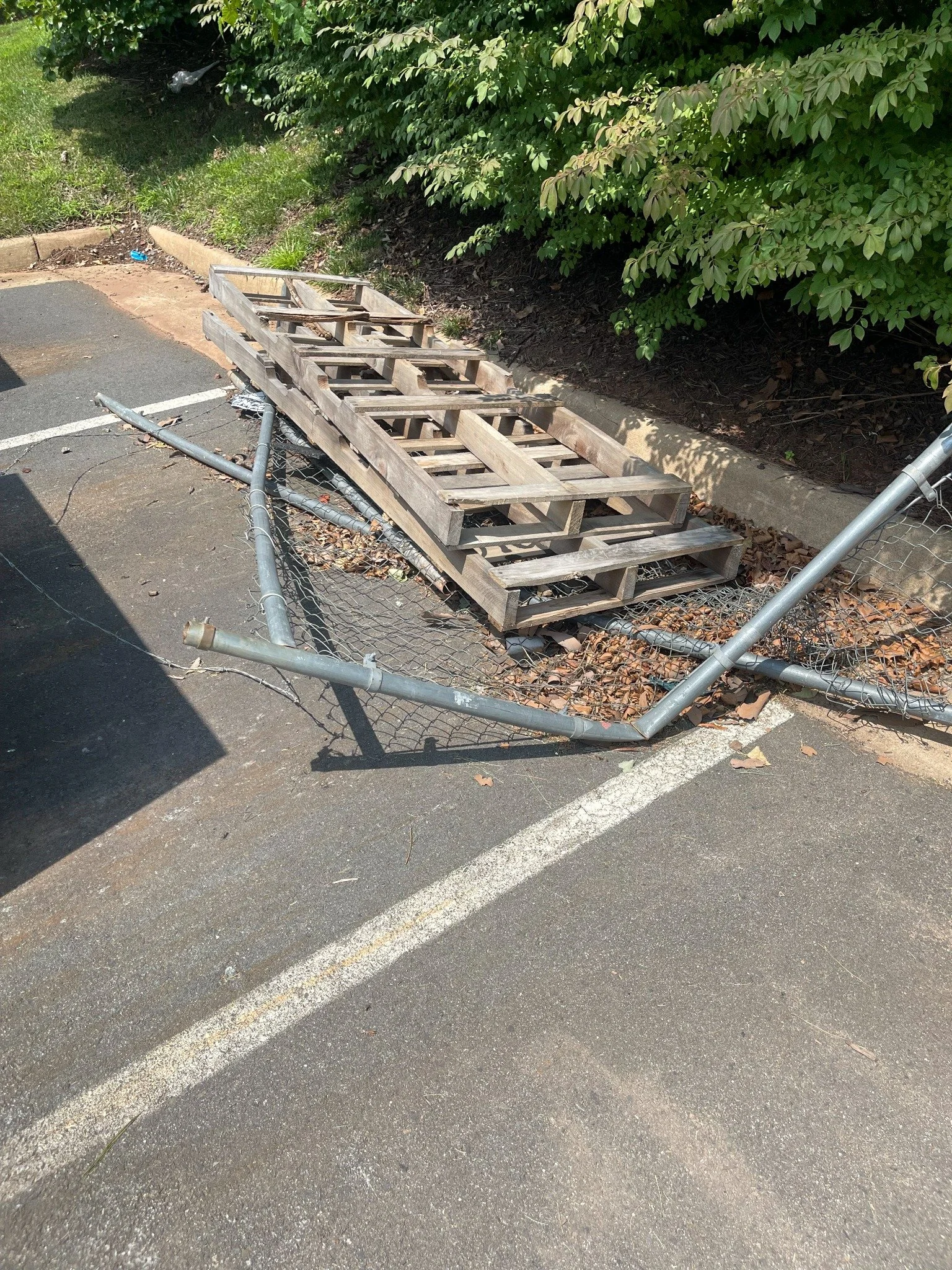 Storage unit cleanout project — wood pallets and fencing staged for removal.