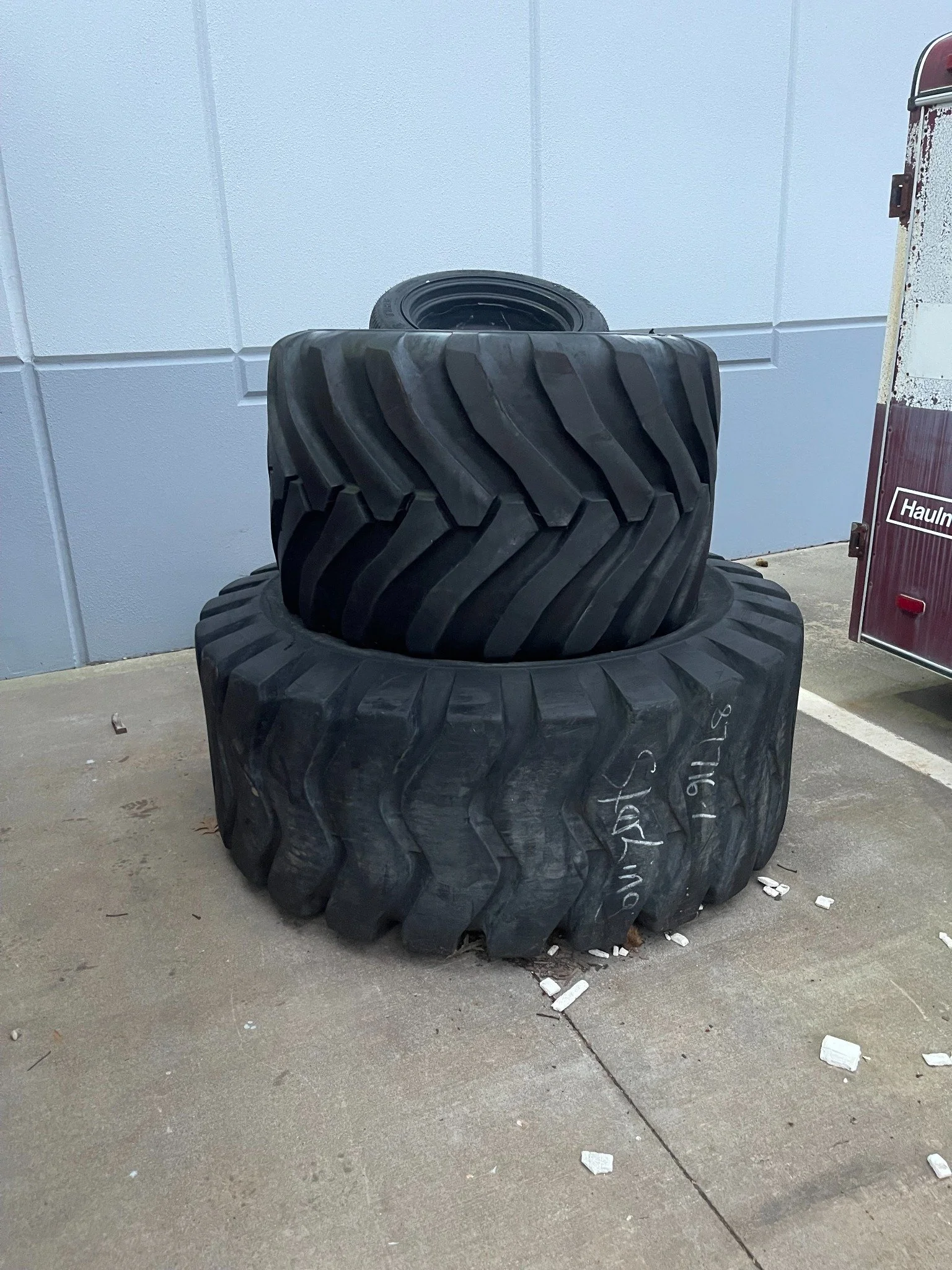 Farm tire disposal project — large agricultural tires staged beside the trailer.